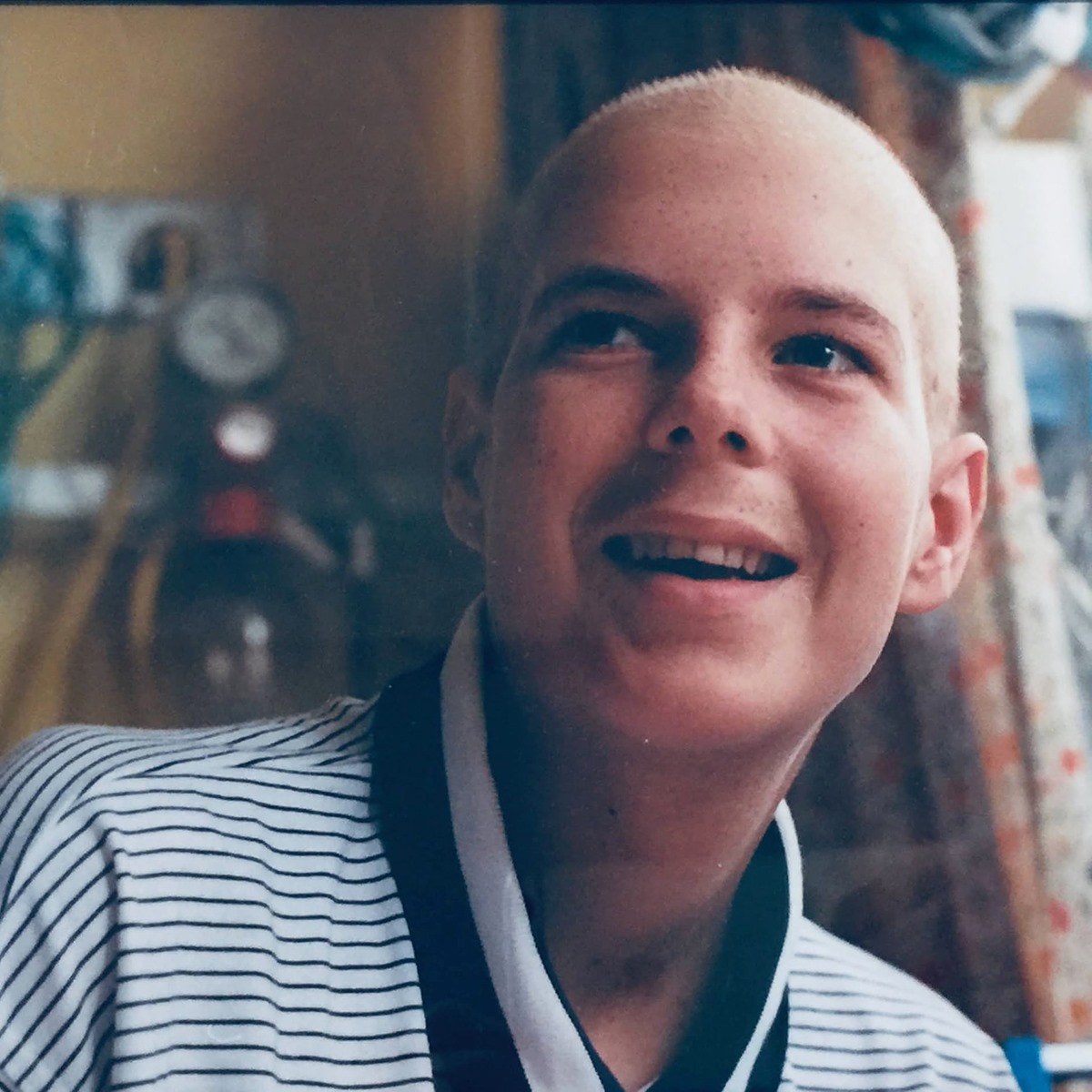 Chris Lucas2 Chris Lucas, a young man wearing a striped t-shirt smiles as he looks off camera.