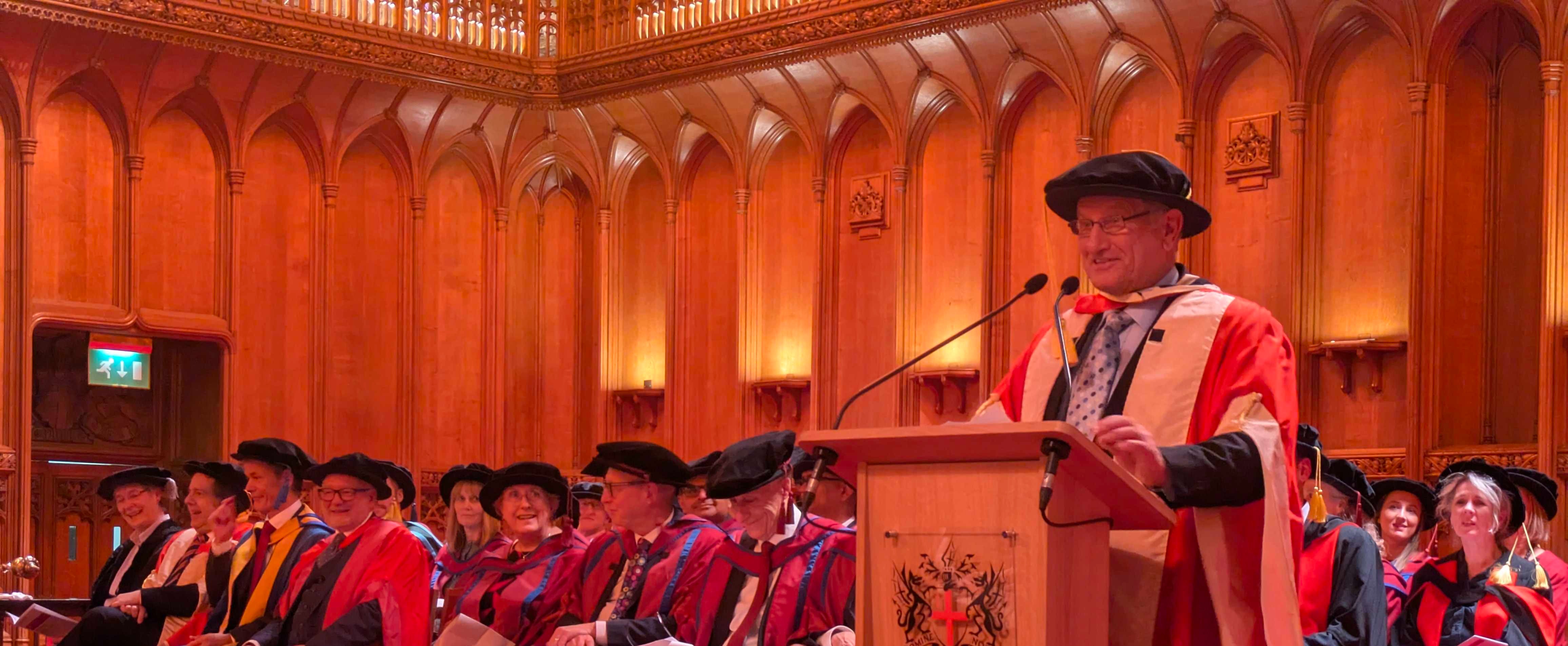 PXL_20251027_162600406 Bob Champion standing at the podium at London's Guildhall, after being awarded an honorary doctorate by the ICR
