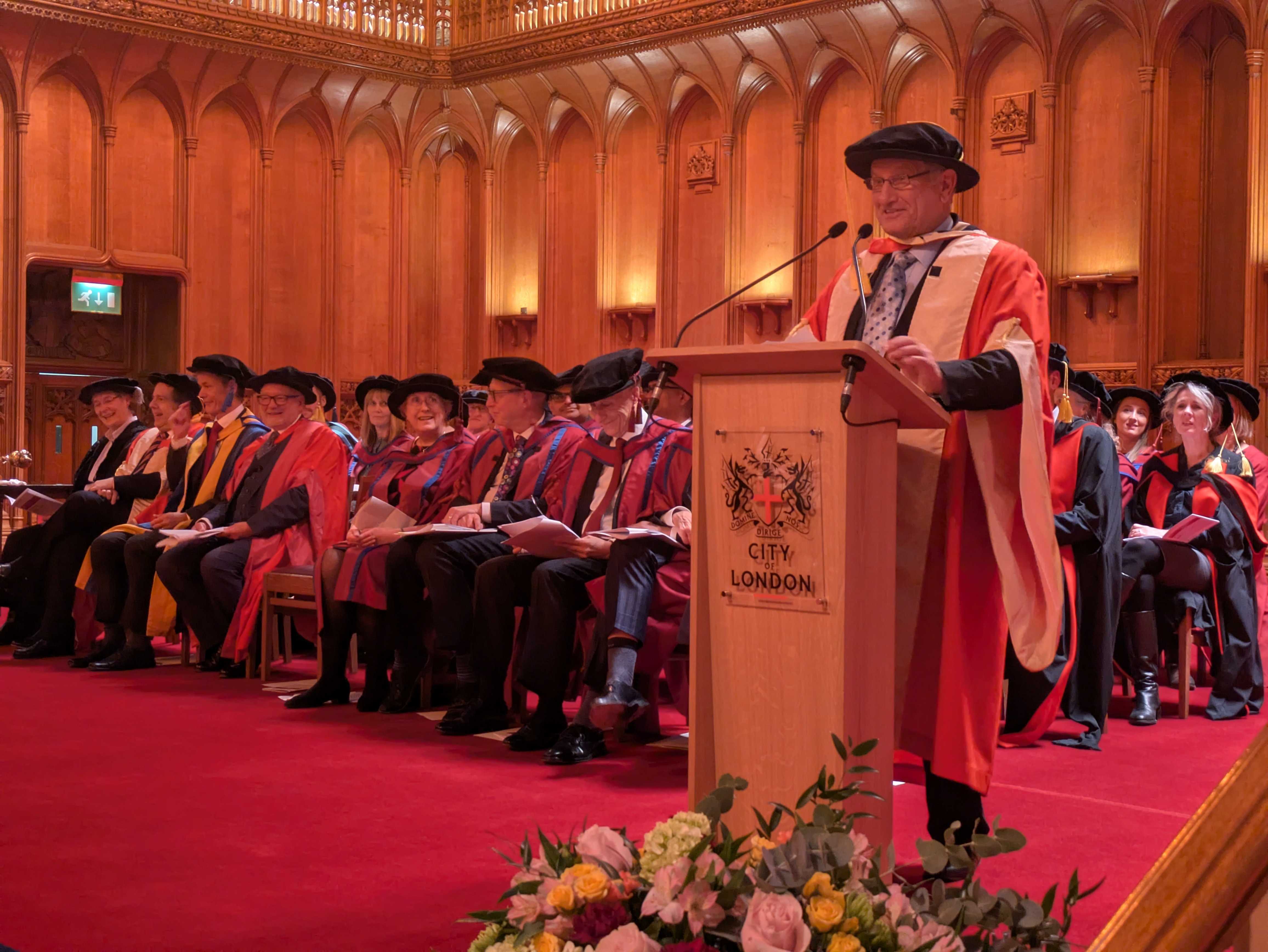 PXL_20251027_162600406 Bob Champion standing at the podium at London's Guildhall, after being awarded an honorary doctorate by the ICR