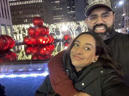 Sonia Bhandal with her fiancee in front of Christmas lights