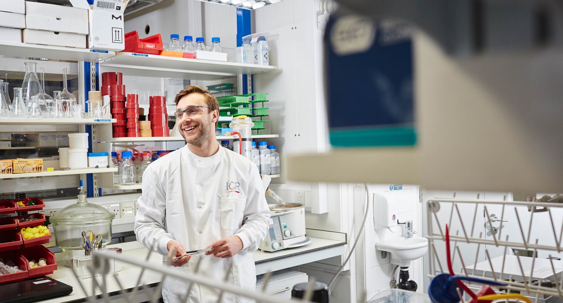 Researcher smiling in the lab, wearing a lab coat