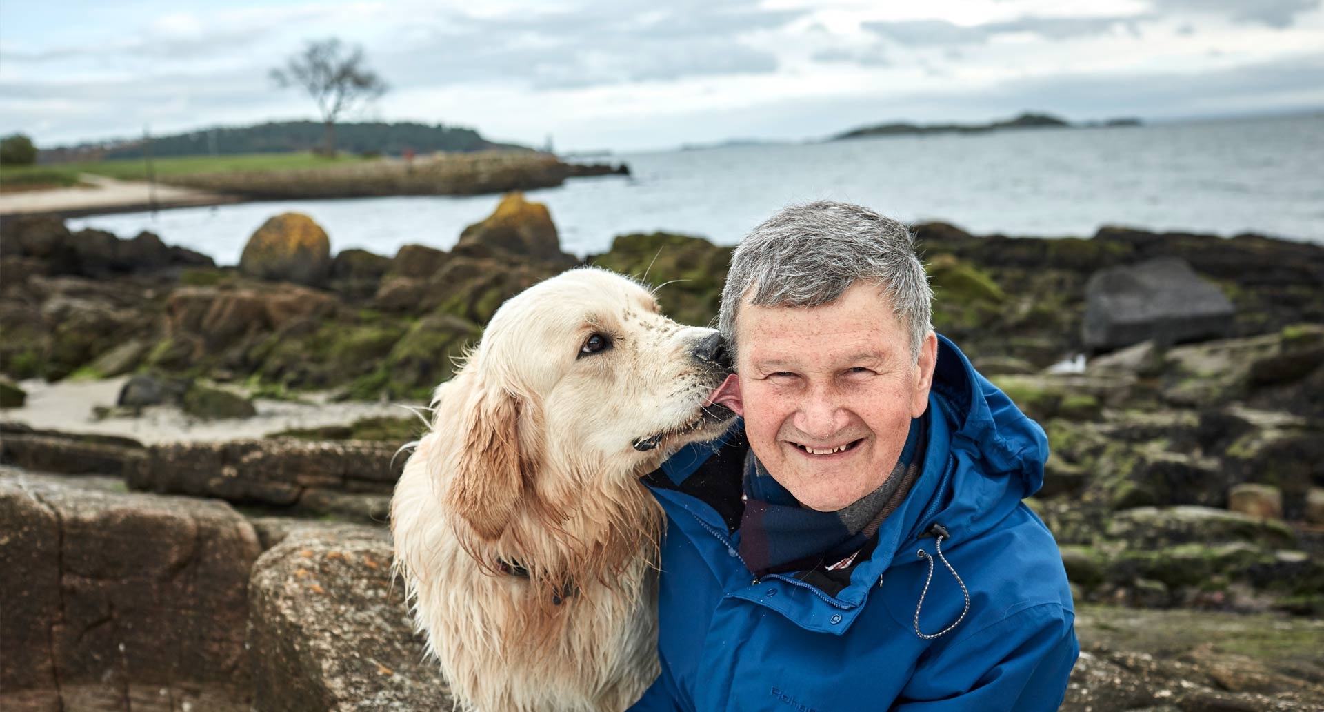 A previous cancer patient by the sea with his dog