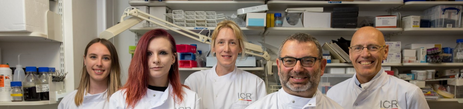 Five scientists in lab coats smiling