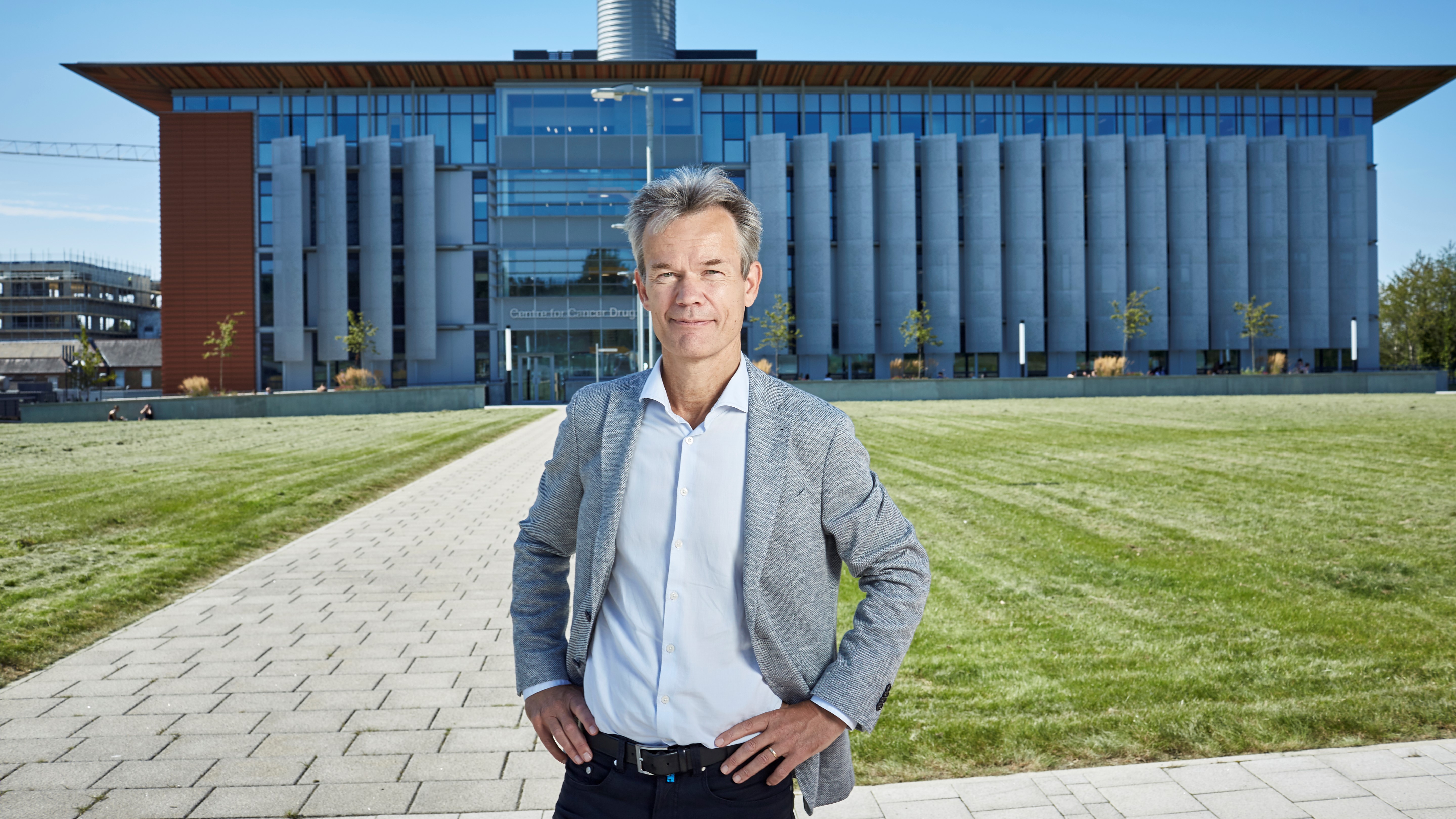 Professor Kristian Helin stood outside, hands on hips, in front of the ICR's Centre for Cancer Drug Discovery