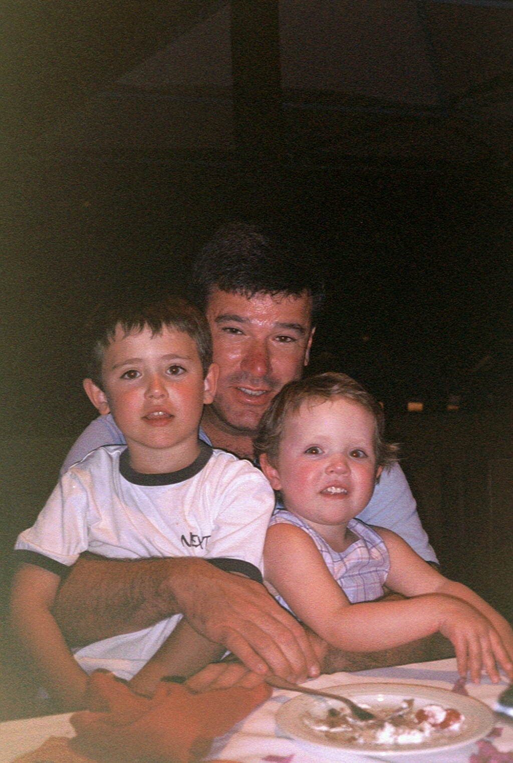 Jamie and Abbie Shaw (children, caucasian) sitting on their dad Mike's lap