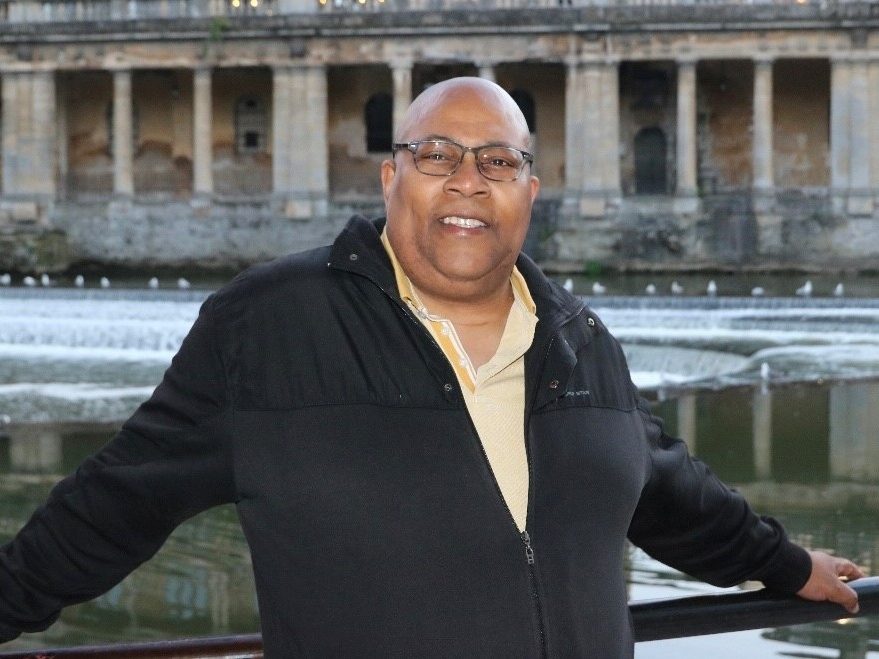 Alfred Samuels leaning against a fence