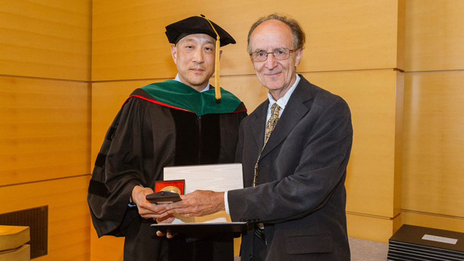 Andrew Kung, Chair of the Department of Pediatrics at MSK, presents the ICR's Professor Mel Greaves with the annual Society of Memorial Sloan Kettering Prize at the 2018 GSK commencement