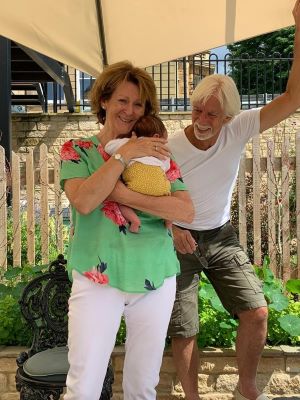 Angela Terry is standing holding her baby grandchild Matilda and husband Robert is next to her. They are both smiling