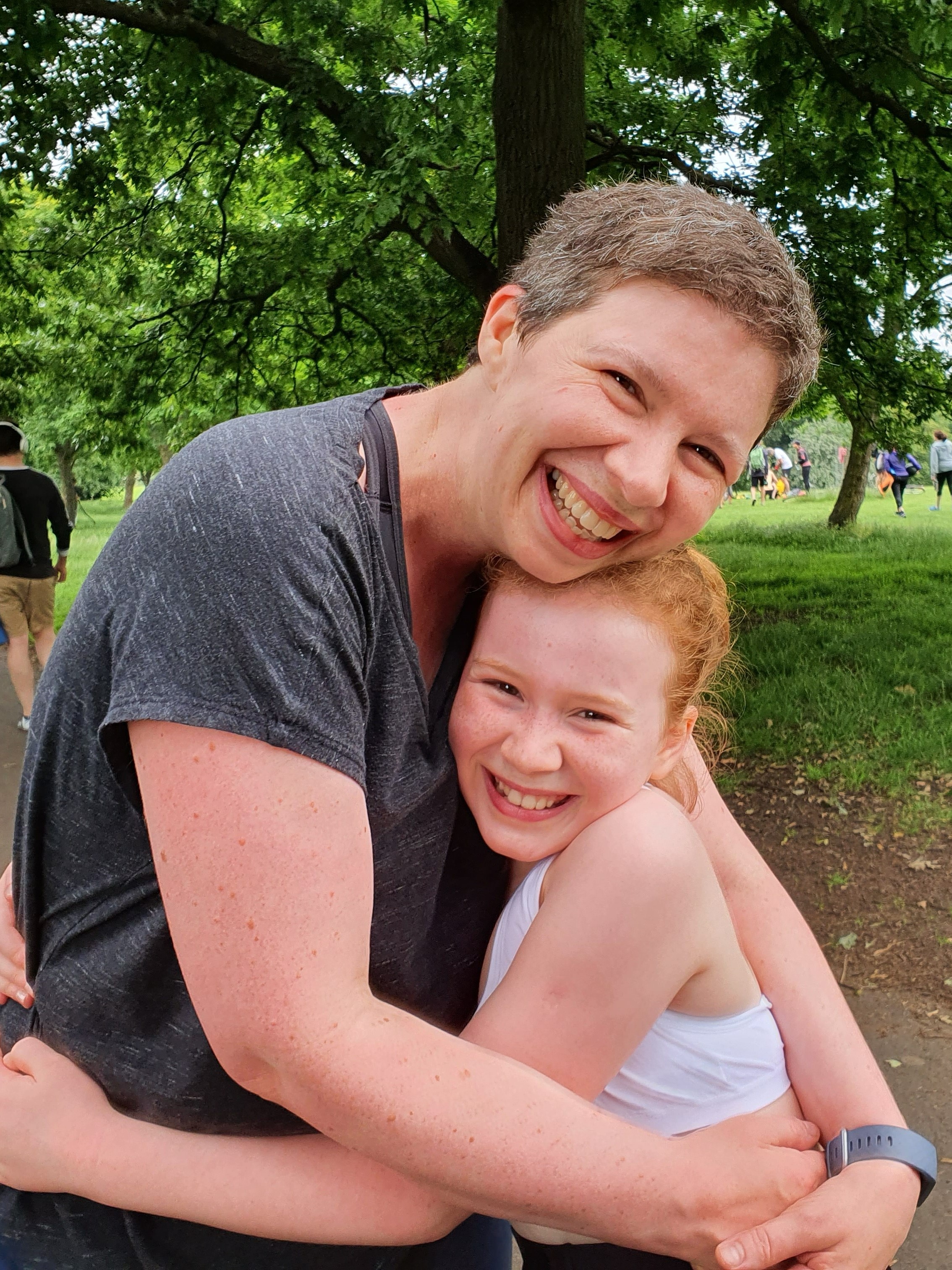 Annie in running gear, leans down to hug her daughter