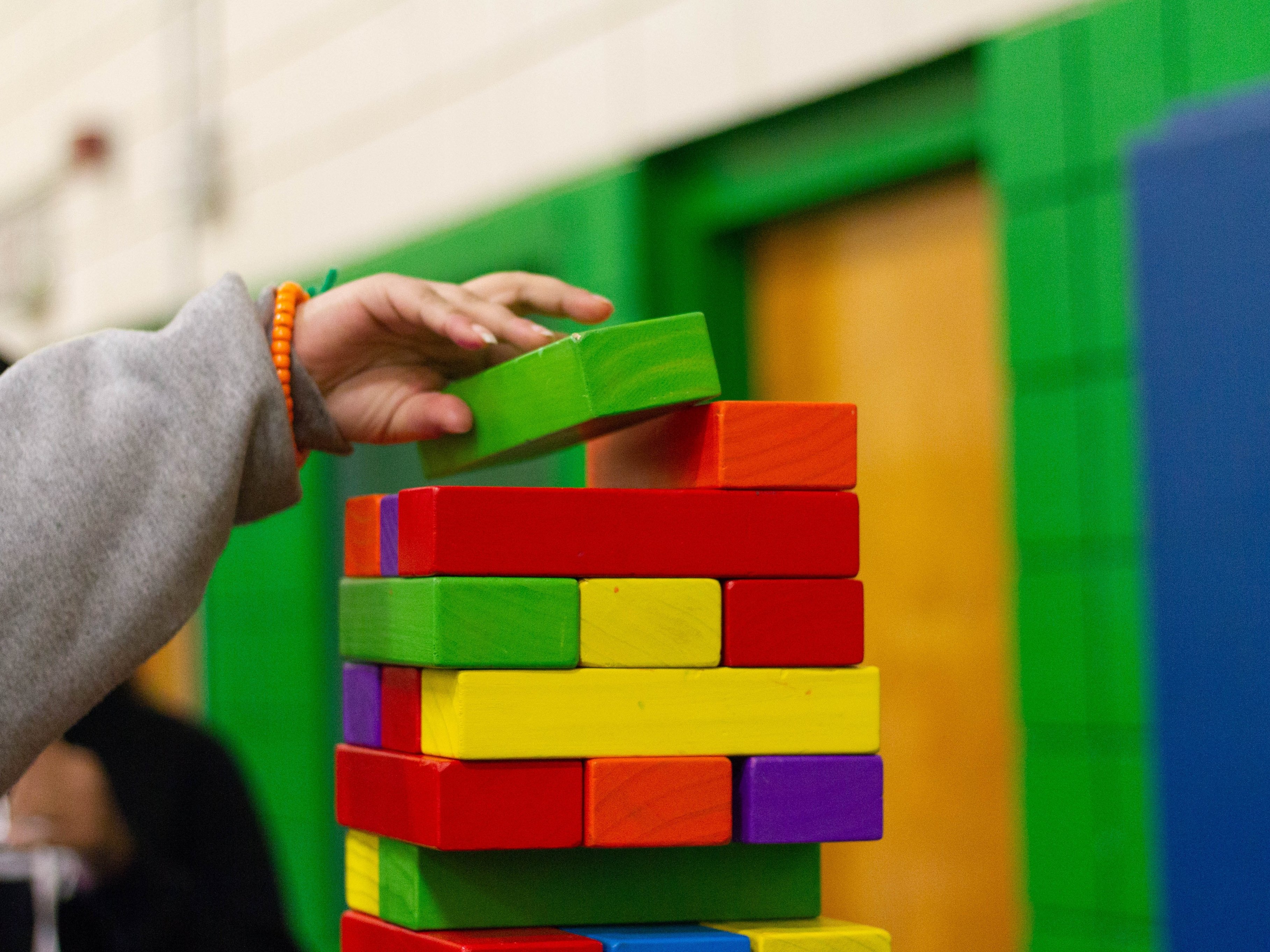 Child building jenga tower A child building a colourful jenga tower