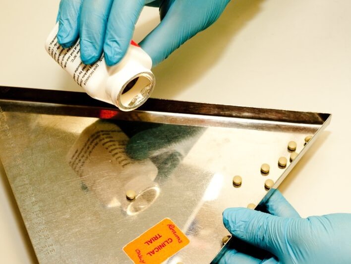 Hands dispensing tablets for a clinical trial