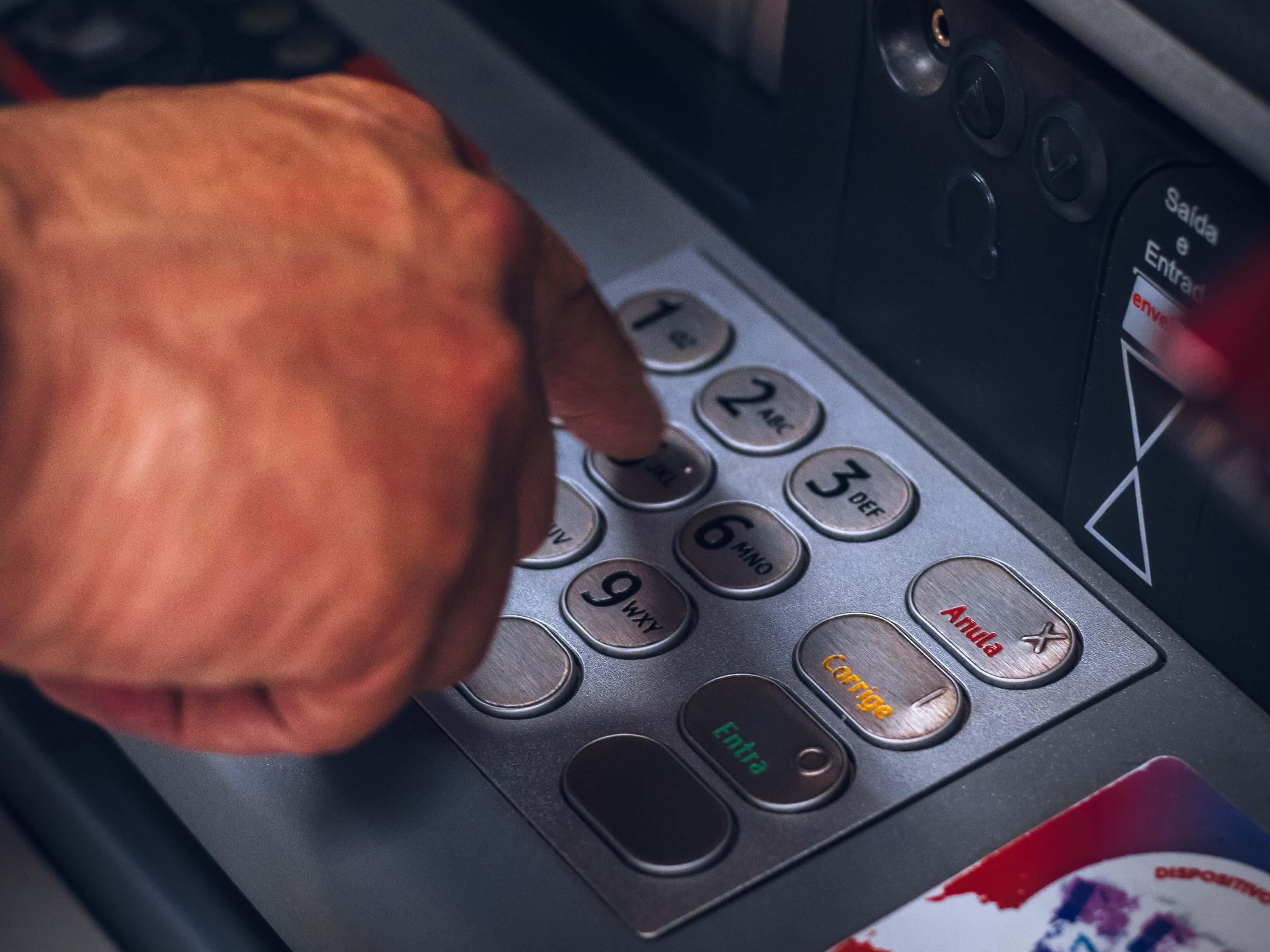 Hand typing bank code at ATM