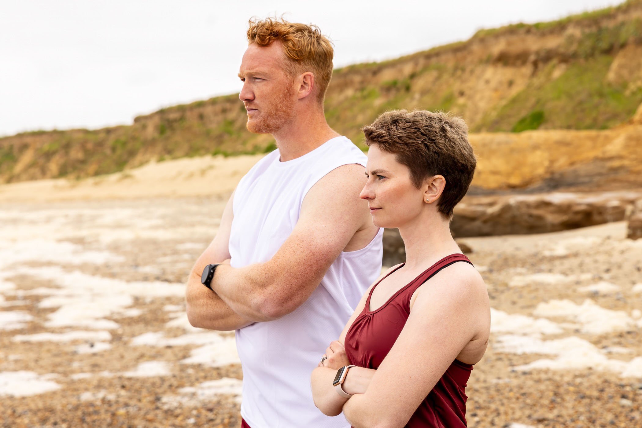 Erin and Greg Rutherford stand side by side on a beach