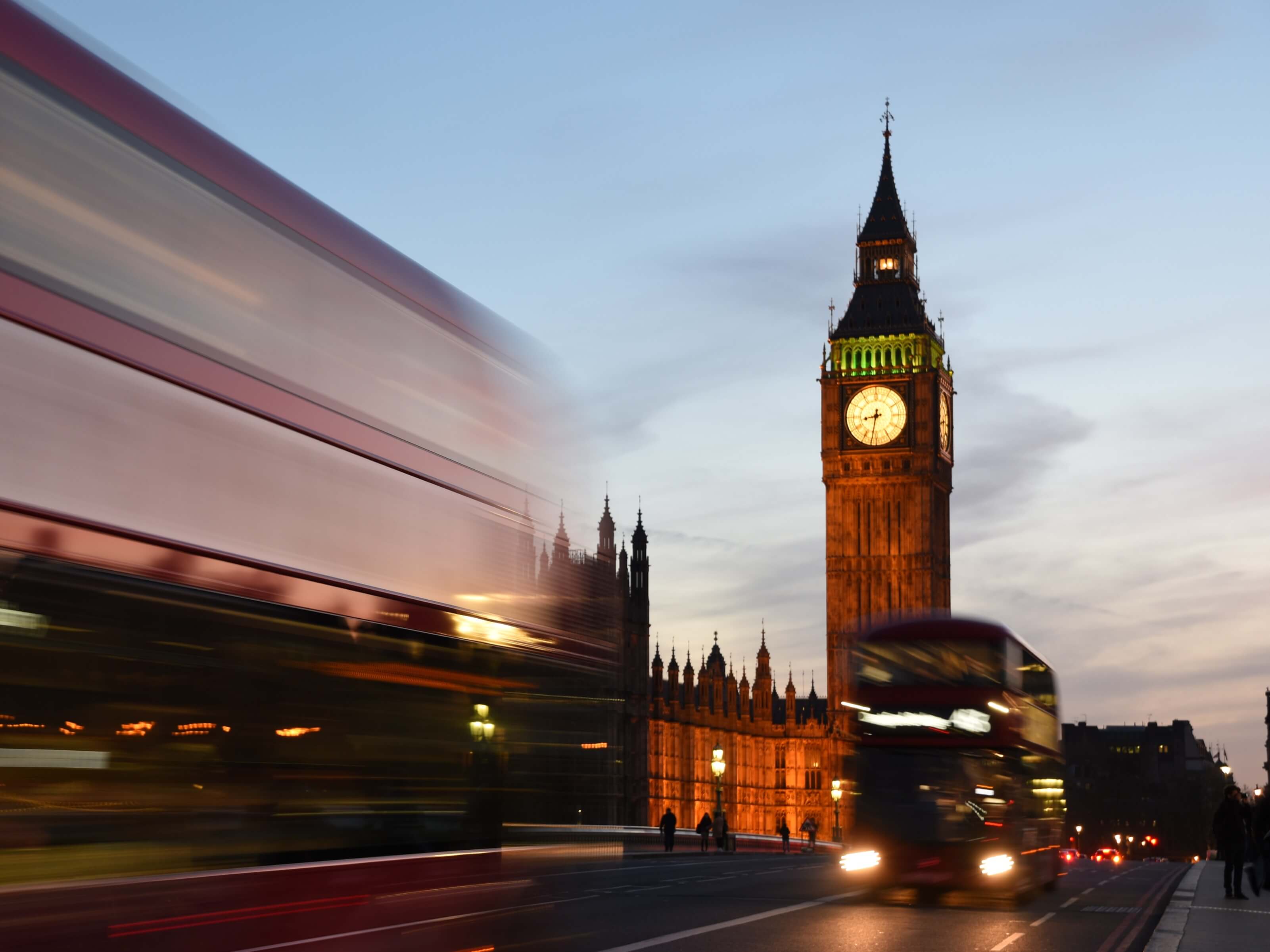 View of Big Ben and London buses at night