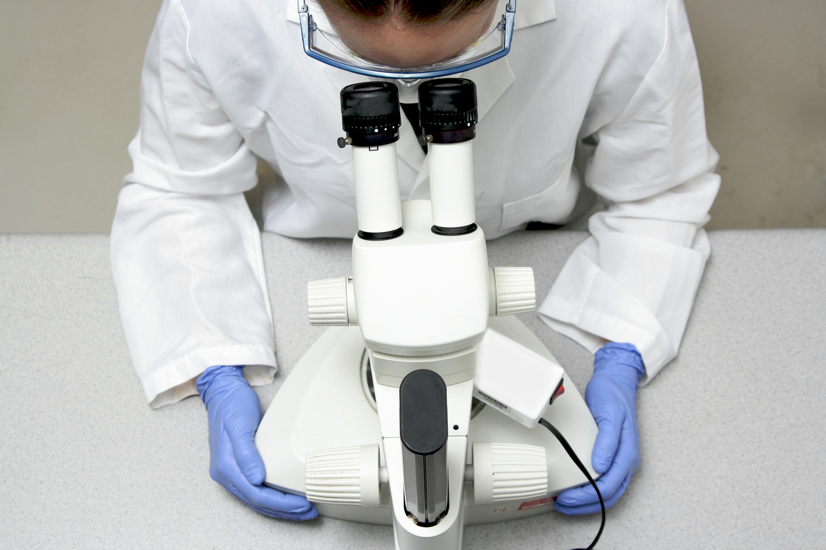 scientist looking through microscope