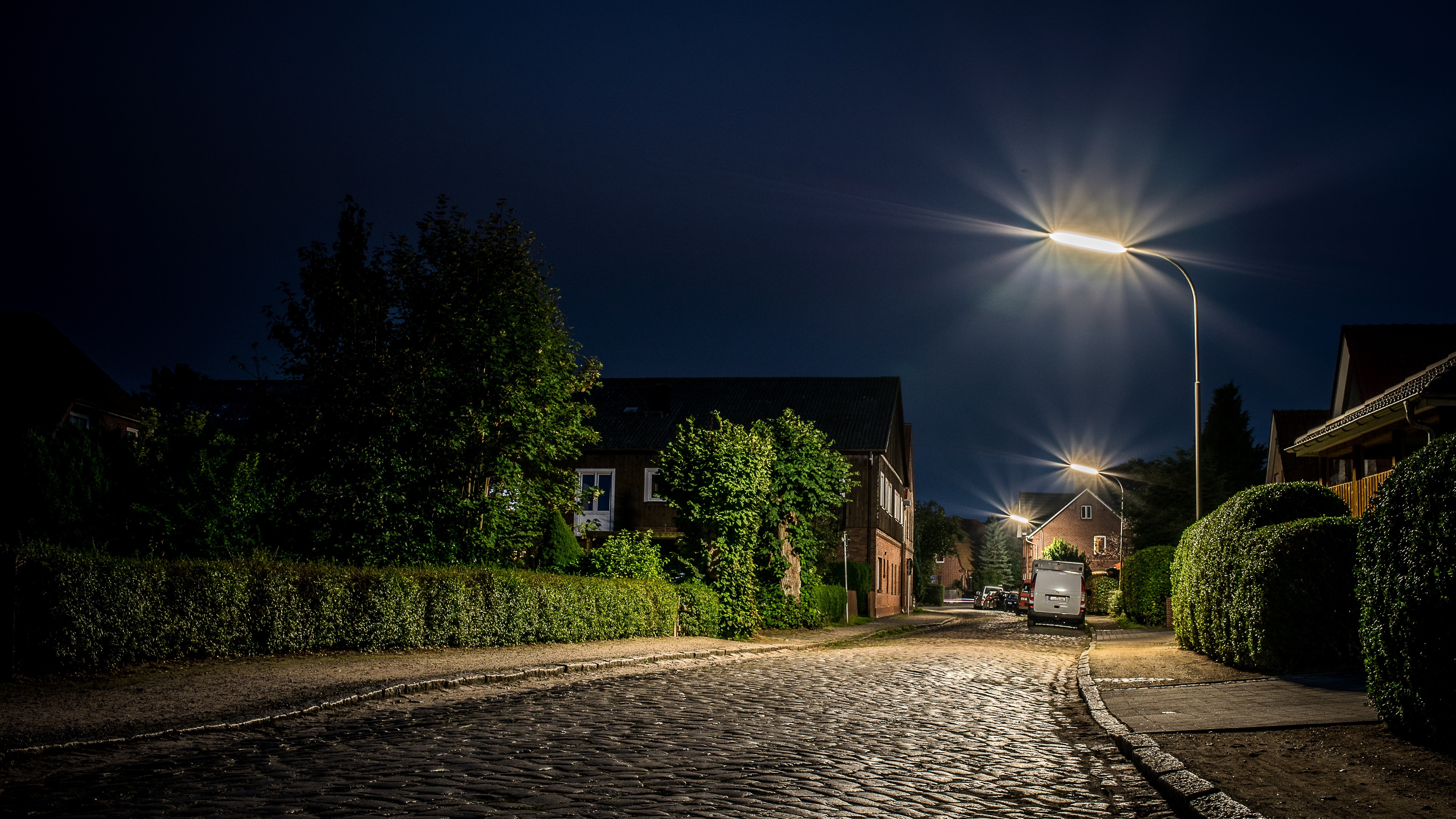 Street light illuminating houses and a cobbled street.