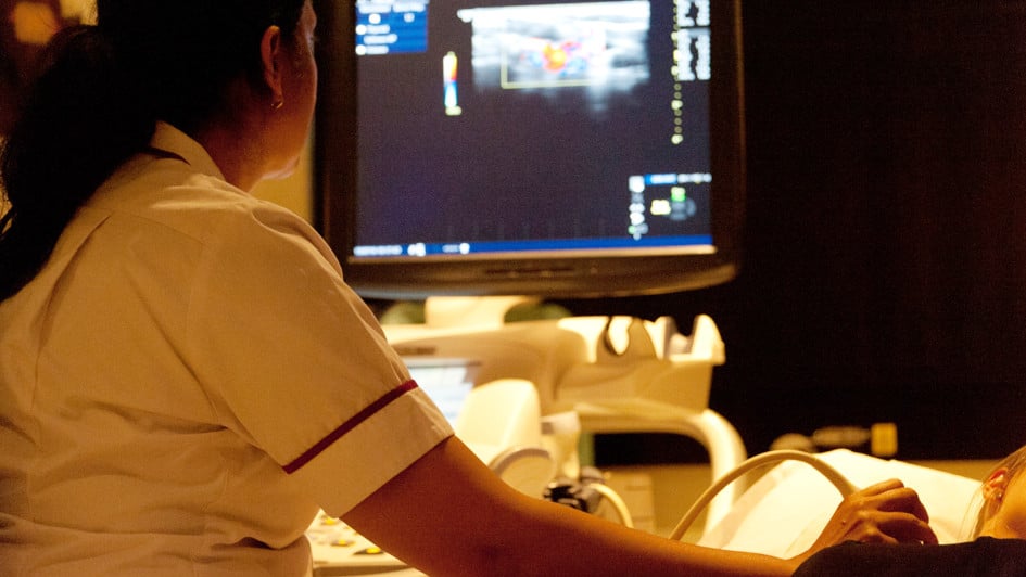 A nurse using ultrasound to image a region of a patient's body