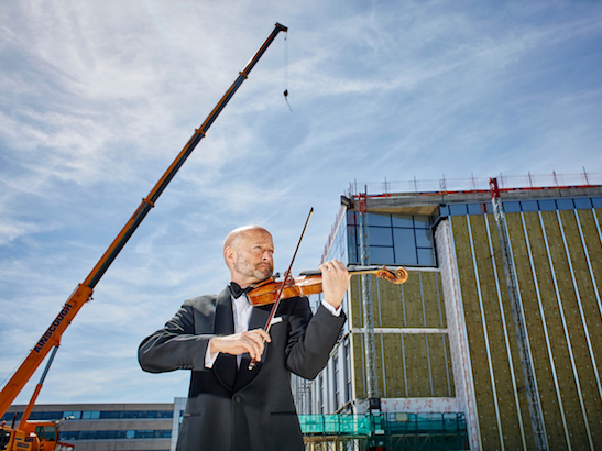 Musician from Royal Philharmonic Orchestra performing the 'Unfinished symphony' outside the Centre for Cancer Drug Discovery