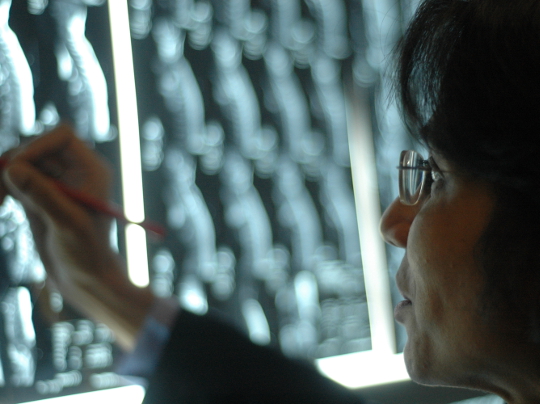 Professor Nandita de Souza in front of scans