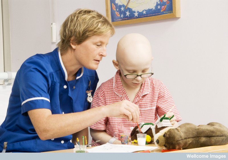 Staff nurse playing with a young boy in hospital. He is undergoing treatment for a childhood cancer. Wellcome Images 2007, Creative Commons by-nc-nd 4.0