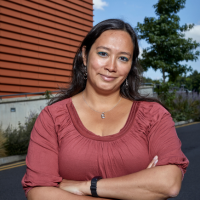 Dr Esther Arwert stands with folded arms in front of the Centre for Cancer Drug Discovery