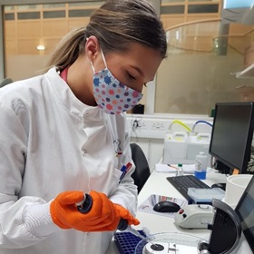 Isabel Nichols in the lab, using a pipette