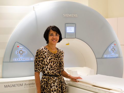 Nandita deSouza in front of an MRI machine